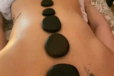 Pedras quentes alinhadas sobre as costas durante a massagem